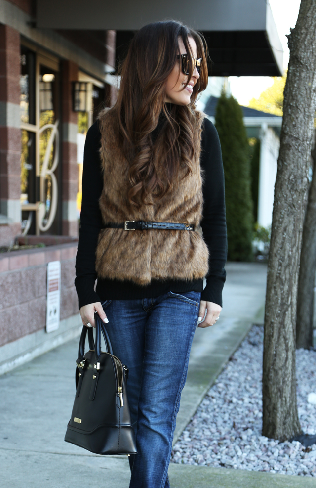 black turtleneck with a brown fur vest